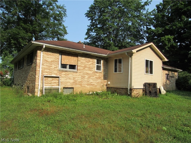 rear view of property featuring a lawn