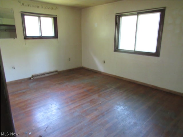 unfurnished room with wood-type flooring and a baseboard radiator