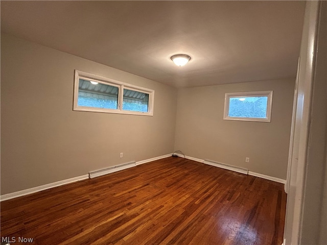 empty room featuring hardwood / wood-style flooring and a baseboard radiator