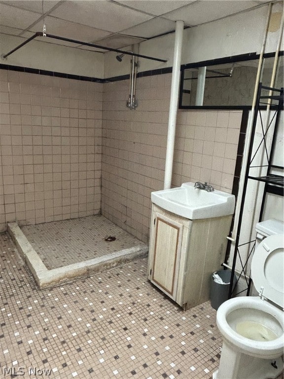 bathroom featuring tile patterned floors, toilet, and a paneled ceiling