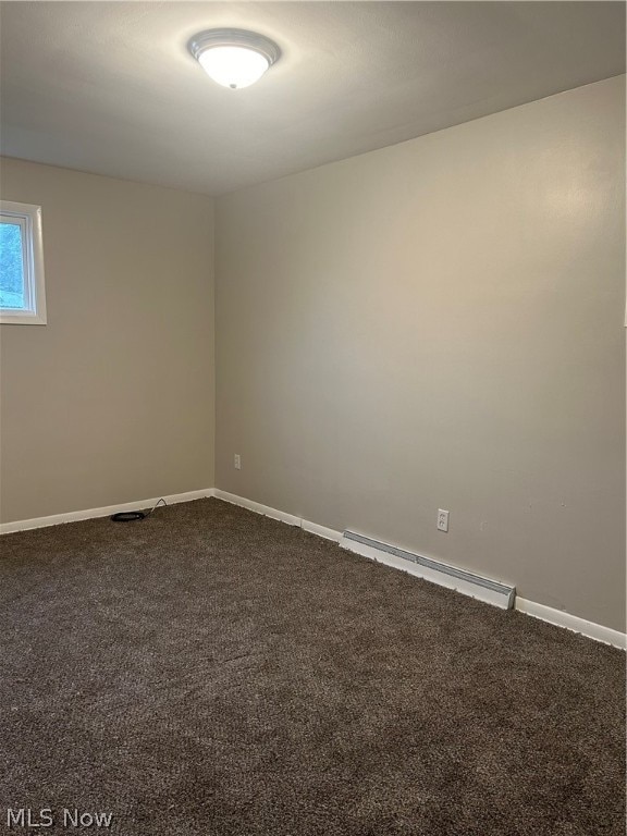 carpeted empty room with a baseboard radiator