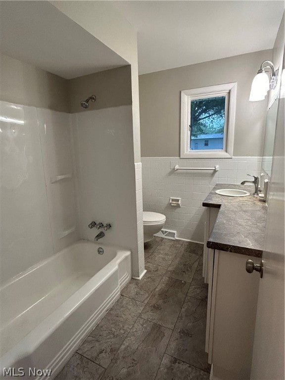 full bathroom with tile patterned flooring, toilet, vanity, tile walls, and decorative backsplash