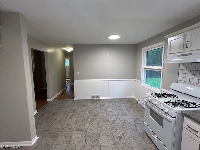 kitchen featuring decorative backsplash, white cabinets, light wood-type flooring, white range with gas cooktop, and custom range hood