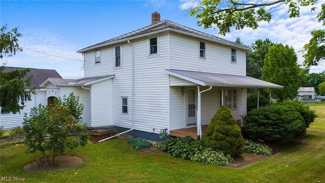 rear view of property with a yard