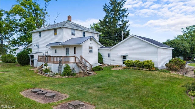 back of house featuring a wooden deck and a lawn