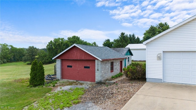 exterior space featuring a garage, an outbuilding, and a front lawn