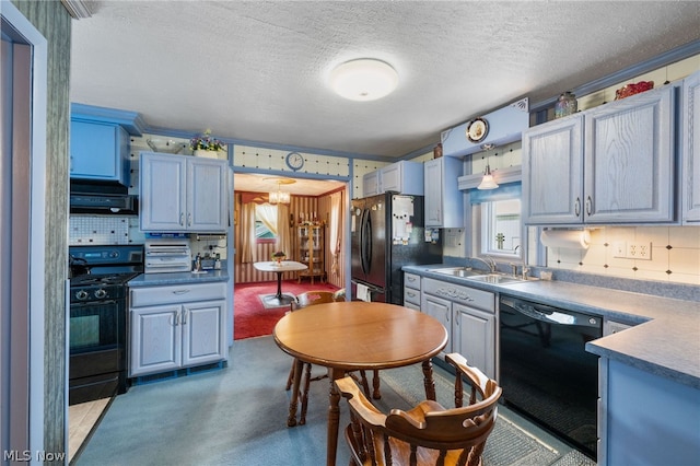 kitchen featuring black appliances, ventilation hood, sink, blue cabinetry, and a textured ceiling