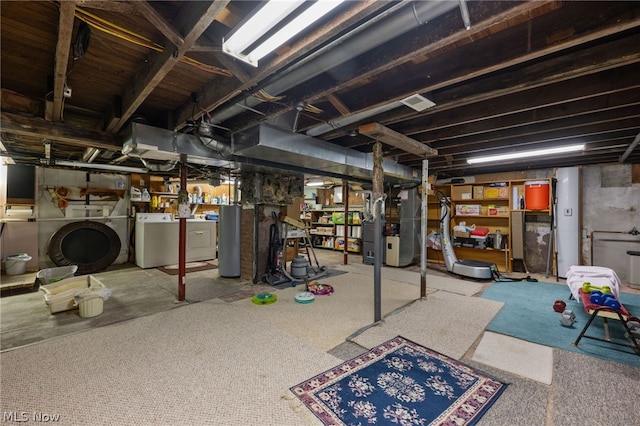 basement featuring washing machine and clothes dryer, light carpet, heating unit, and gas water heater