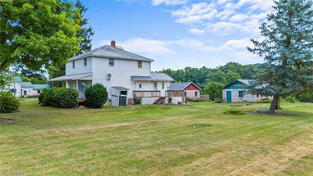 rear view of property with a deck and a lawn