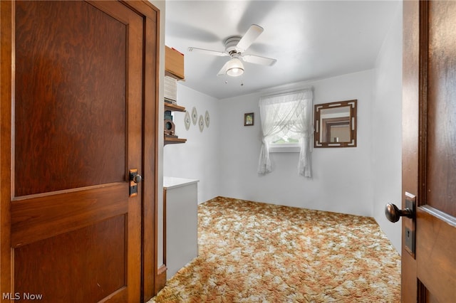 carpeted spare room with ceiling fan