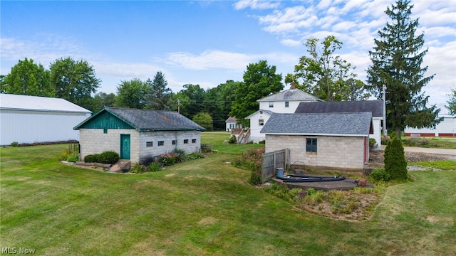 rear view of house with an outdoor structure and a yard