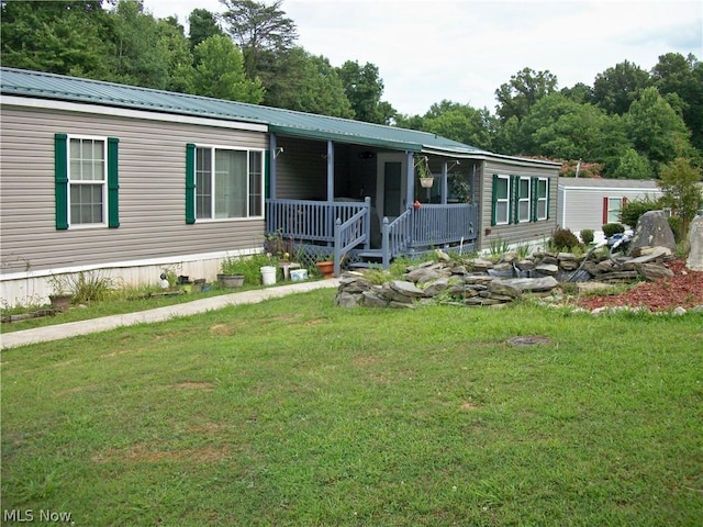 manufactured / mobile home with covered porch and a front lawn