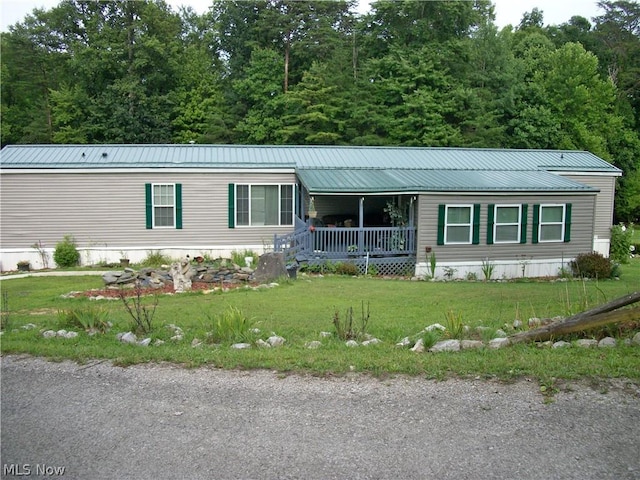 manufactured / mobile home featuring a porch and a front yard