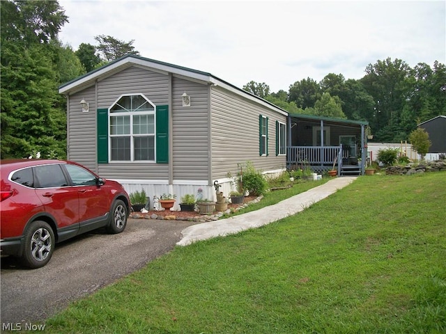 view of side of property with a porch and a lawn