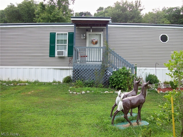 doorway to property featuring a yard and cooling unit