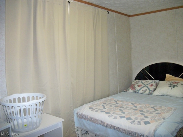 bedroom with a textured ceiling and crown molding