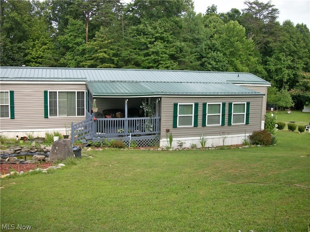 manufactured / mobile home with covered porch and a front yard