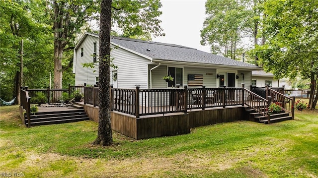 rear view of property with a yard and a deck