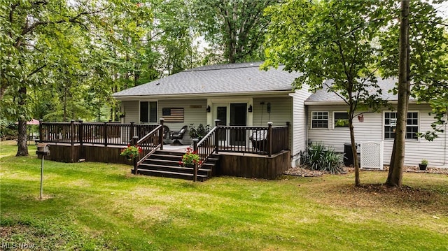 rear view of property featuring a deck and a yard