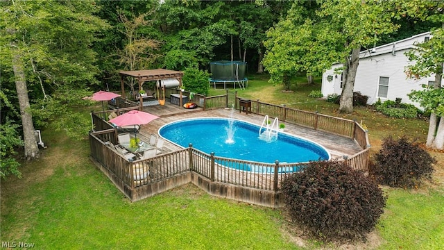 view of pool featuring a deck, a yard, and a trampoline