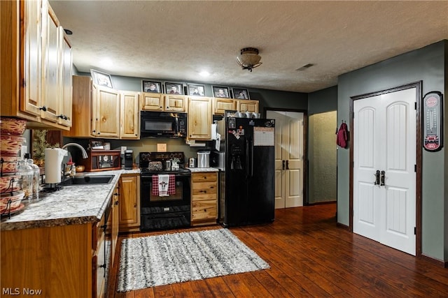 kitchen with sink, a textured ceiling, black appliances, and dark hardwood / wood-style flooring