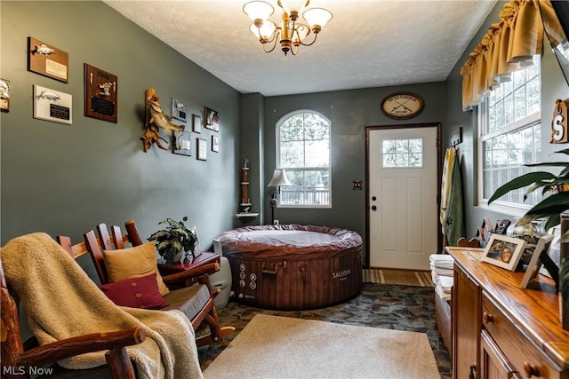 sitting room featuring a textured ceiling and an inviting chandelier