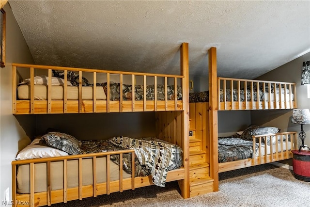 bedroom with carpet, lofted ceiling, and a textured ceiling