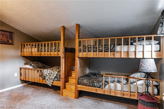 bedroom featuring carpet flooring, a textured ceiling, and lofted ceiling