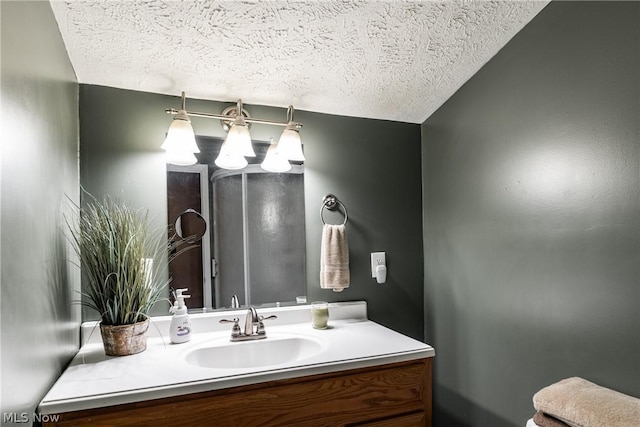 bathroom featuring vanity, a textured ceiling, and lofted ceiling