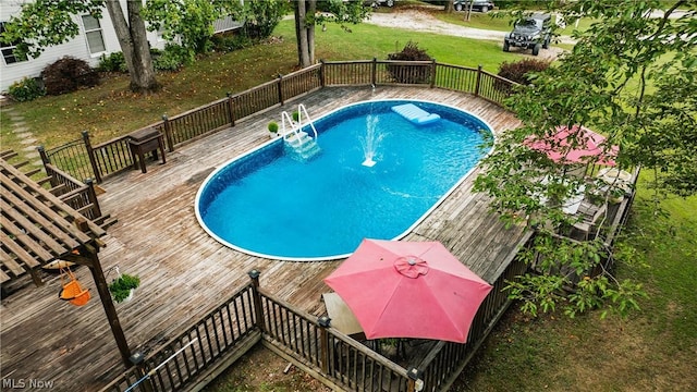 view of pool featuring a deck and a lawn