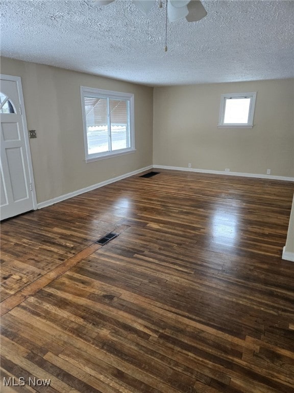 spare room featuring ceiling fan, dark hardwood / wood-style flooring, and a textured ceiling