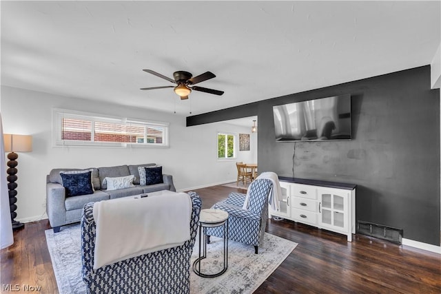 living room featuring ceiling fan and dark wood-type flooring