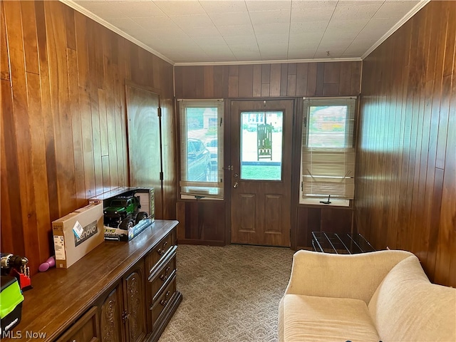 carpeted entrance foyer with crown molding and wooden walls