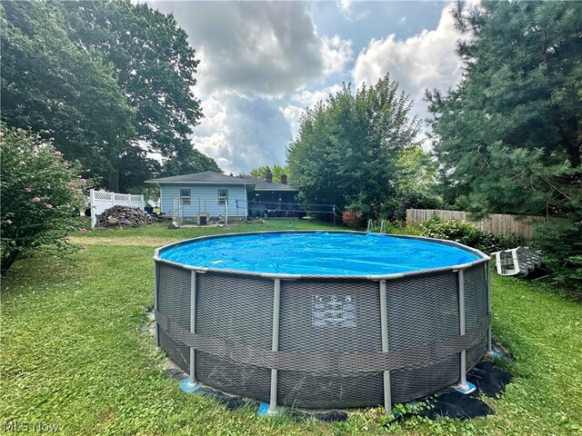 view of pool featuring a lawn