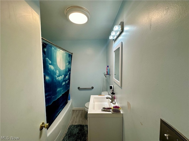 full bathroom with hardwood / wood-style floors, vanity, shower / tub combo, and toilet