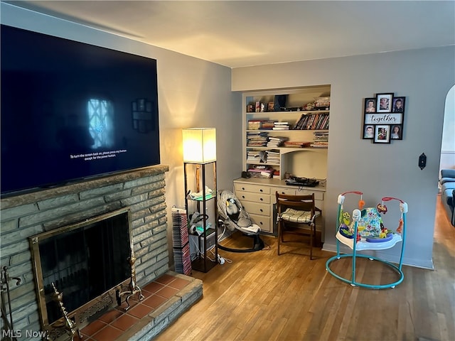 living room featuring built in shelves and hardwood / wood-style floors