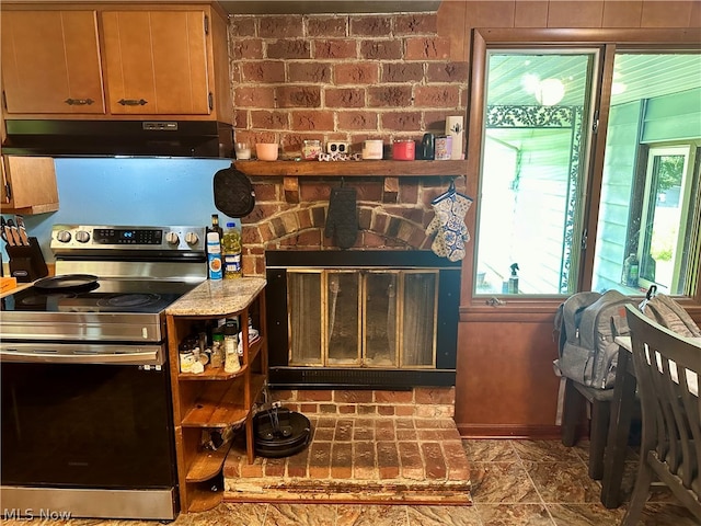 kitchen with a wood stove, tile patterned floors, brick wall, and electric stove