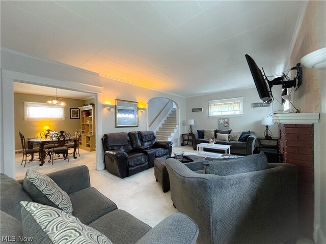 carpeted living room with an inviting chandelier