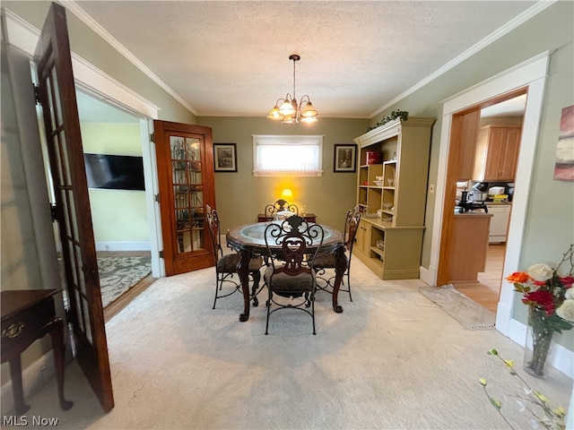 dining room with an inviting chandelier, crown molding, light carpet, and a textured ceiling