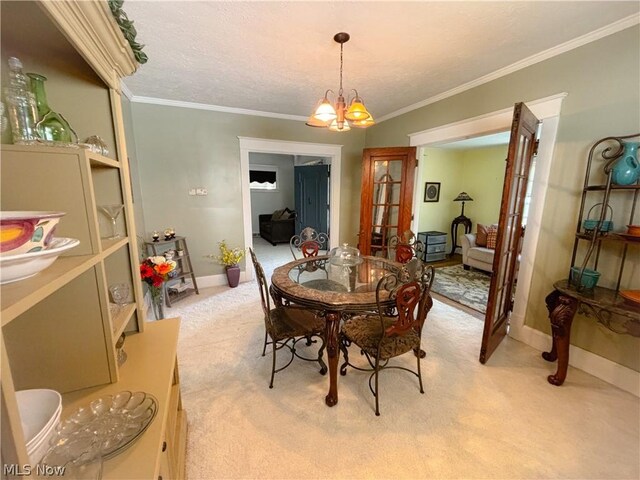 dining area featuring ornamental molding, a chandelier, and light carpet