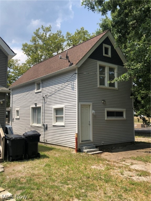 rear view of property featuring a lawn