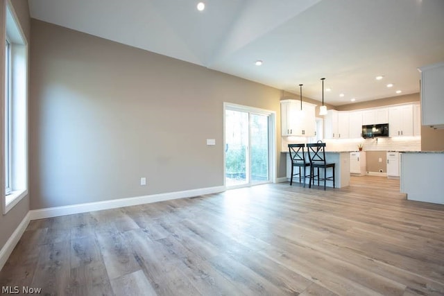 unfurnished living room with light wood-type flooring and plenty of natural light