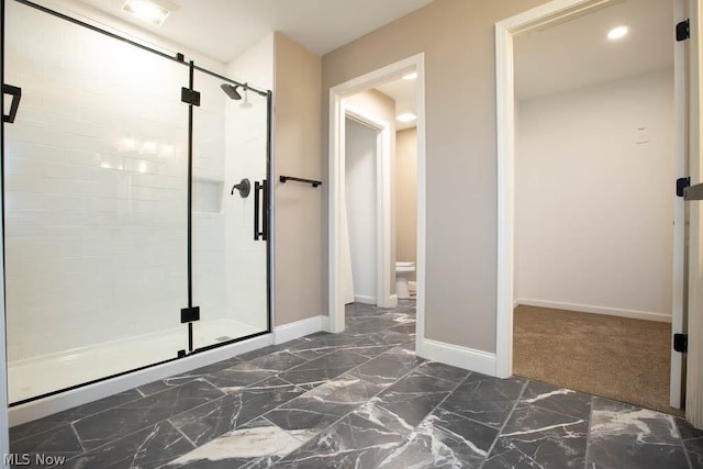 bathroom with a shower with shower door and toilet