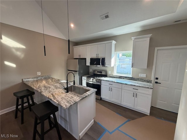 14501 Kennerdown Ave, Maple Heights, OH 44137 - kitchen featuring stainless steel appliances, white cabinetry, dark wood-style floors, and vaulted ceiling