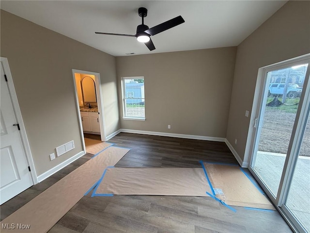 14501 Kennerdown Ave, Maple Heights, OH 44137 - unfurnished bedroom with dark wood-style floors, access to outside, connected bathroom, and a ceiling fan
