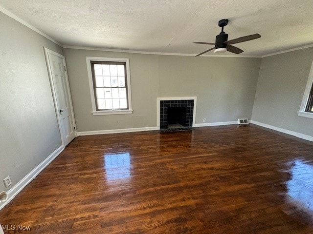 unfurnished living room with crown molding, a textured ceiling, ceiling fan, hardwood / wood-style flooring, and a tile fireplace