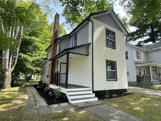 view of front facade featuring a front lawn, central AC unit, and a porch