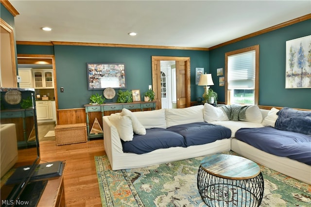 living room with light hardwood / wood-style flooring and ornamental molding