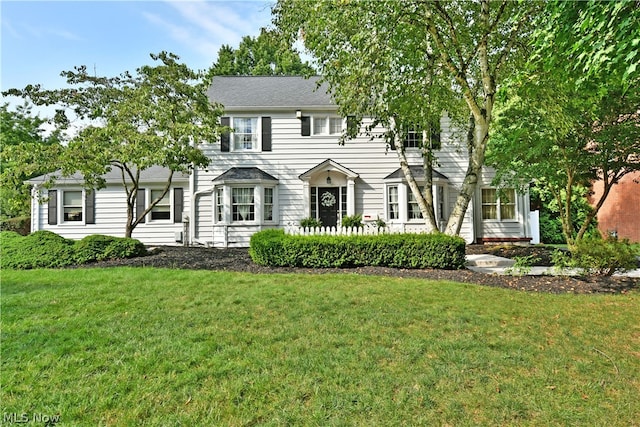 colonial inspired home featuring a front lawn