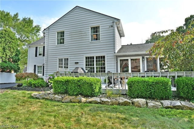 rear view of property with a lawn